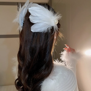 Macro detail of the elegant white feather and pearl hair clip worn by a model from the side