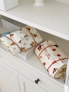 Detail of rolled canvas organizers featuring bear prints and elastic rope closures
