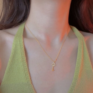 Elegant gold plated S925 silver necklace with sparkling clover key pendant worn by model
