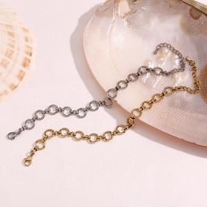Detailed view of textured circular link bracelets in antique gold and silver finishes