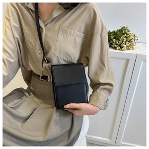 Minimalist black PU leather crossbody bag shown on model with gold hardware detail