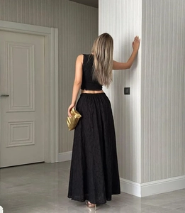 Détail du haut sans manches noir et de la jupe longue avec broderie florale et texture fine