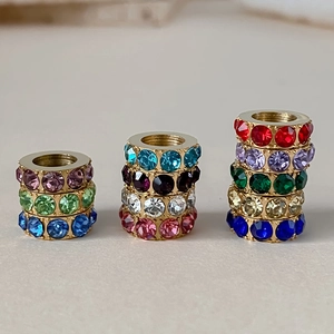 Macro view of gold-plated large hole spacer beads with vibrant colorful rhinestones