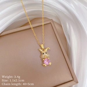 Detailed shot of a rabbit-shaped gold necklace with pink heart gem in a gift box