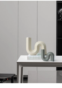 Detailed view of modern S-shaped ceramic vases with matte vertical ribbed texture
