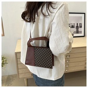 Sac bandoulière marron à monogramme porté avec une chemise blanche et jupe en jean
