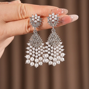 Detailed view of silver flower earrings with white pearls and sparkling rhinestones