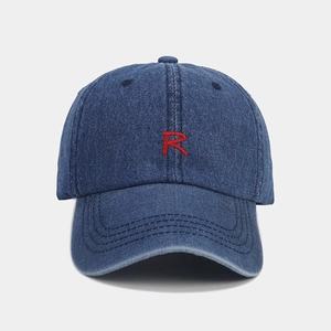 Detailed view of red R embroidery on dark blue denim baseball cap with parallel stitching
