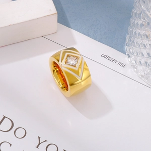 Macro shot of gold wide band ring featuring square zircon and white geometric pattern