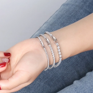 Three elegant S925 sterling silver tennis bracelets with cubic zirconia on denim background