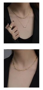 Close-up of gold double-layer necklace with paperclip chain and rhinestone oval links