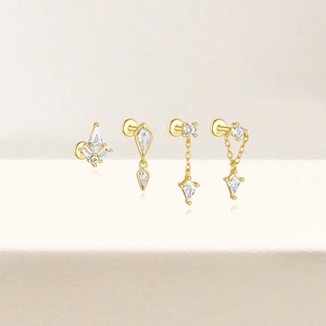 Détail de quatre puces d'oreilles en argent S925 plaqué or avec zircons en forme de cerf-volant