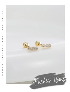 Detailed macro of S925 silver 14K gold bar earrings featuring three round cubic zirconia studs