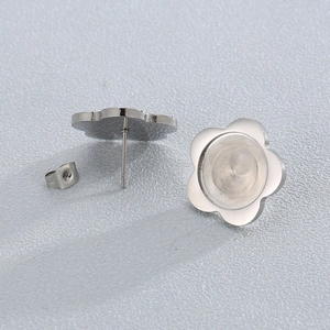 Macro detail of stainless steel flower stud earring base and matching backing components
