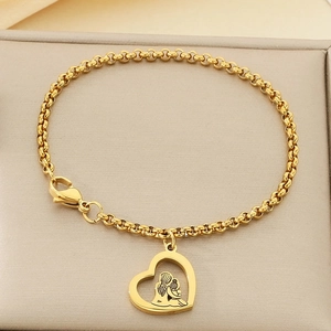 Détail du pendentif cœur doré avec silhouette mère-enfant sur bracelet de perles