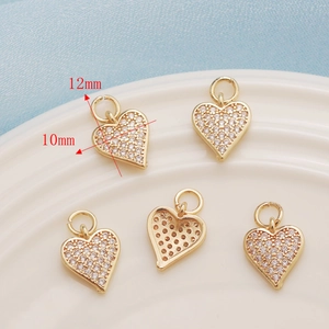 Close-up of five gold heart pendants with cubic zirconia inlay measuring 10x12mm