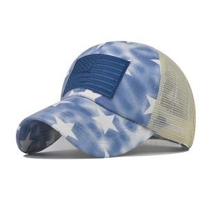 Detail of blue tie-dye cotton baseball cap with star patterns and American flag patch