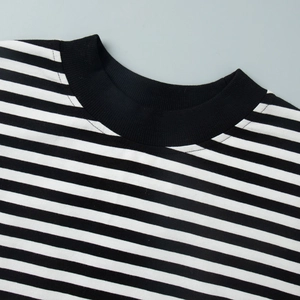 Dettaglio del top a maglia a righe bianche e nere con scollo rotondo a costine nere