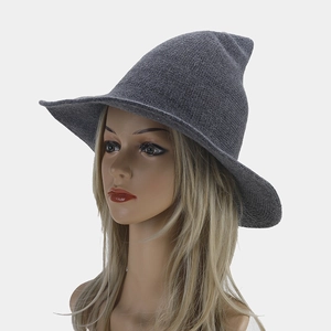 Detail of dark grey knitted witch hat with pointed top and flexible wavy brim