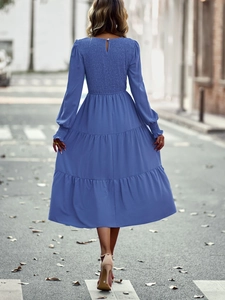 Vue arrière d'une robe midi bleue à manches longues avec dos froncé et jupe à volants