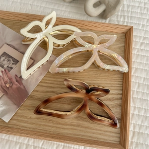 Elegant large butterfly claw clips in cream, pearl, and tortoiseshell with metal trim