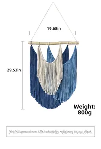 Detail of bohemian hand-woven wall hanging with blue and white cotton tassels on wood