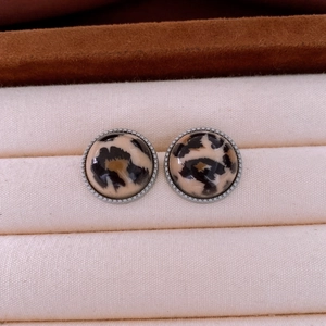 Gros plan sur les boucles d'oreilles rondes en acrylique à motif léopard et bordure