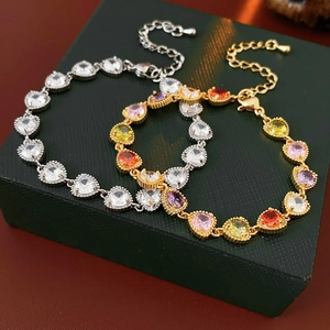 Detailed view of colorful zircon heart bracelets on a textured jewelry box background