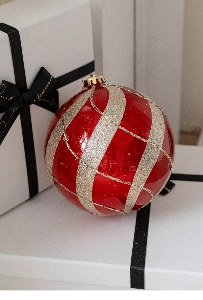 Close-up of a 15cm red and silver glitter Christmas ball on a white gift box decor