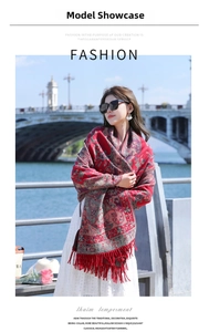 Outdoor shot of a red ethnic shawl with paisley patterns and long tassels on a model