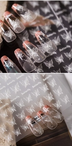Macro shot of 5D embossed white butterfly nail stickers with 3D relief texture detail
