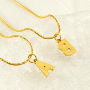 Gold stainless steel snake chain necklace featuring diamond-encrusted A and B pendants