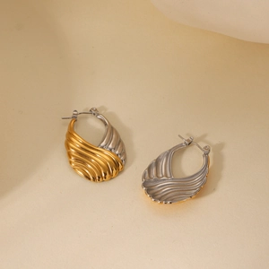 Close-up of two-tone gold and silver water drop earrings with radial pleated texture