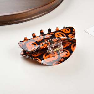 Detail shot of Halloween hair claw clip featuring black and orange pumpkin patterns