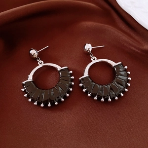 Detail of silver drop earrings with black pleated leather and metal bead edge trim