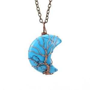 Close-up of tree of life wire wrapping on a crescent moon turquoise stone pendant