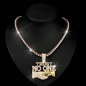 Macro shot of TRUST NO ONE gold pendant with handshake design and tennis chain