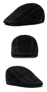 Detail view of black denim beret cap featuring brown stitching and adjustable side buckle