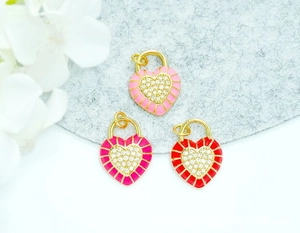 Macro detail of 18K gold plated heart charms with colorful enamel and sparkling crystals