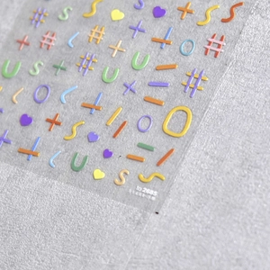 Close-up of 5D colorful embossed nail stickers with 3D letters and heart shapes