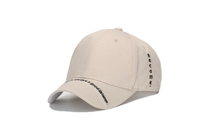 Detail of beige cotton baseball cap with black side embroidery and brim lettering