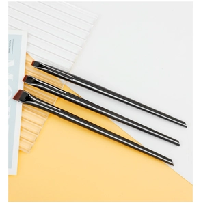 Detailed close-up of three professional angled eyeliner and eyebrow brushes with black handles