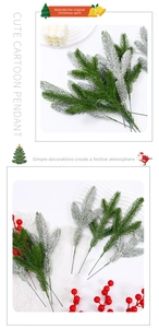 Detail of artificial pine branches with snow flocking and red berries for Christmas DIY