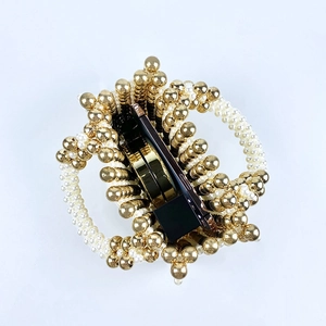 Close-up of beaded handbag showing interior space with a smartphone and cosmetics