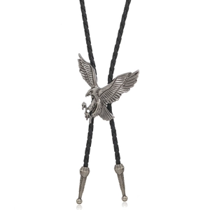 Close-up of vintage eagle bolo tie with black braided leather rope and metal tips