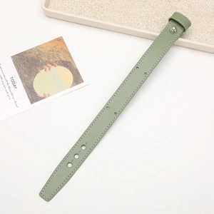 Detail of pea green leather wrist strap with white stitching and silver metal buckle