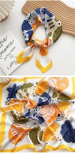 Detailed close-up of mandala floral print silk scarf with folded layers and edge stitching