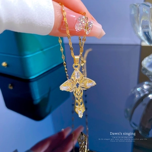 Macro detail of gold cross pendant with hollow design and zircon inlay held by hand