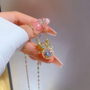 Close-up of a gold reindeer antler necklace with a large crystal and micro-pave zircons
