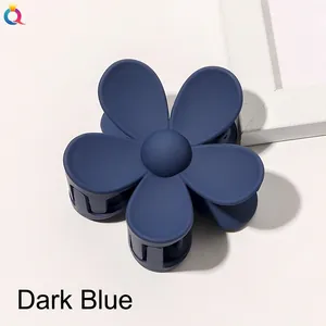 Detailed macro view of navy blue matte flower hair claw with five-petal resin design